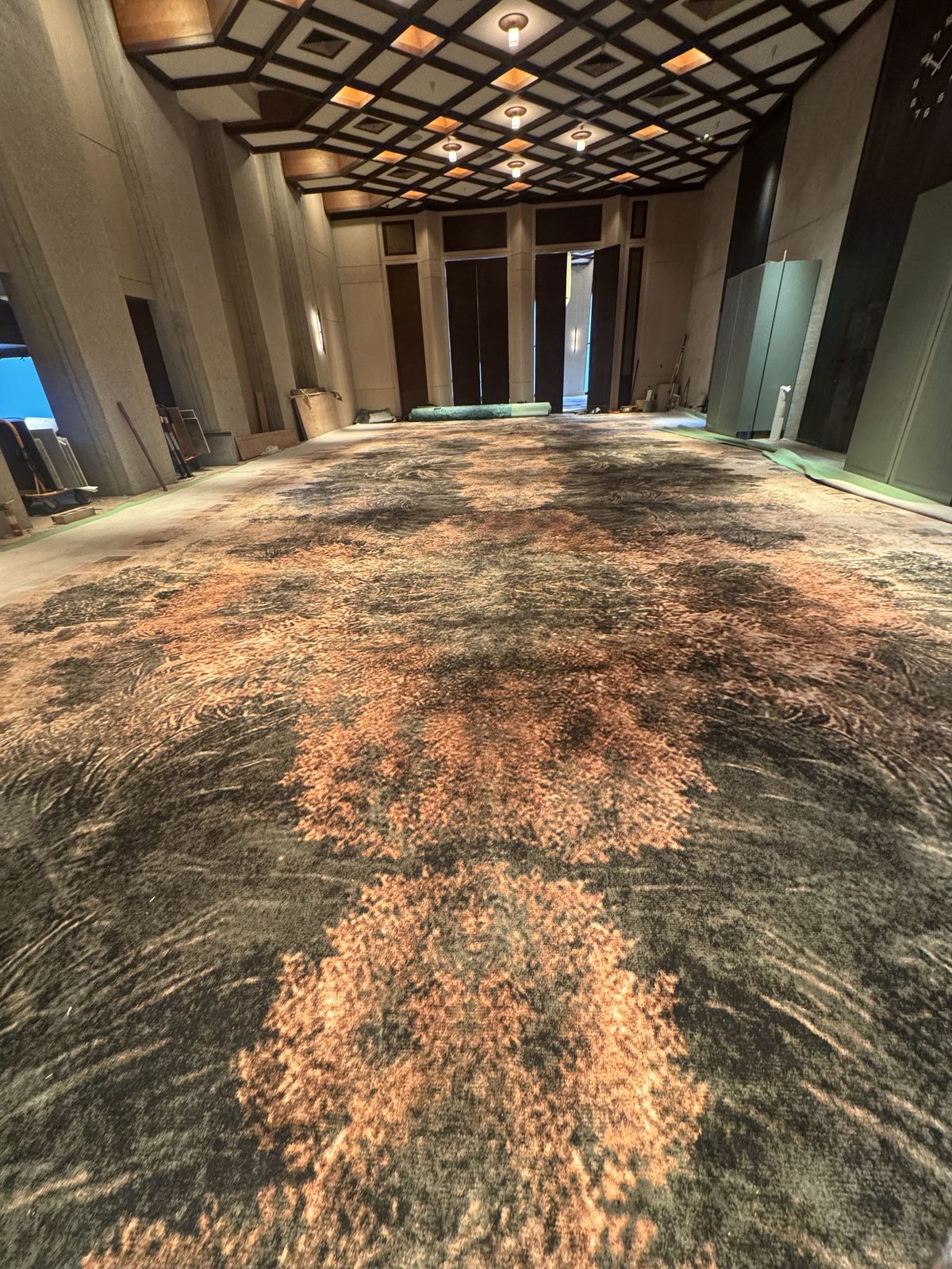 Patterned broadloom carpet installed across a large Houston event hall with a coffered ceiling